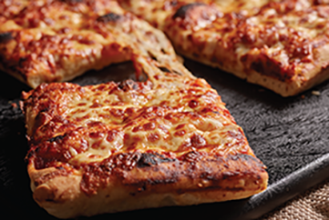 Pizza by a brick pizza oven